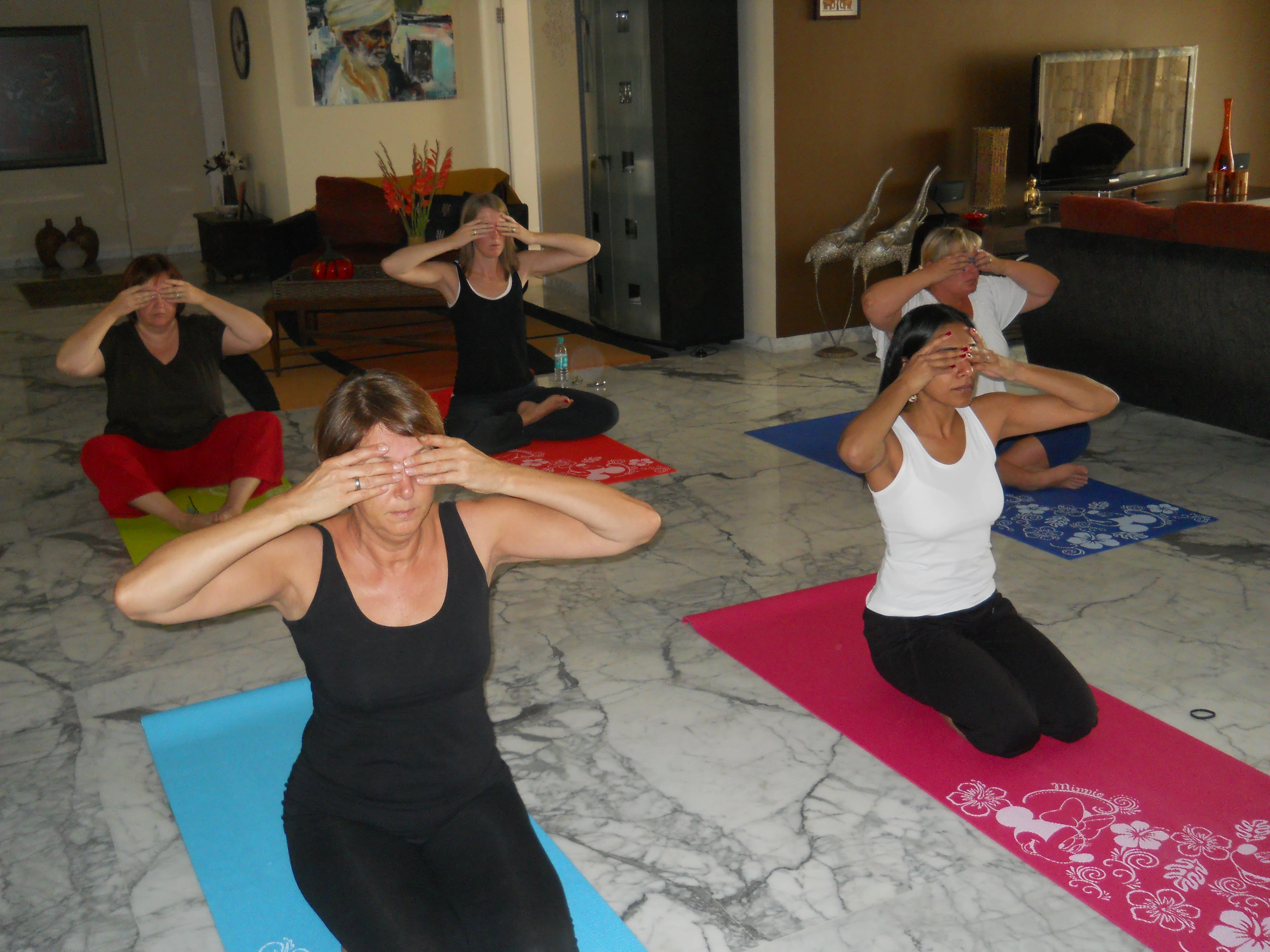 Group practising tree pose together on the beach