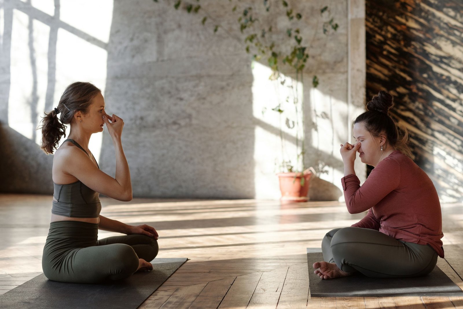 Two students practising alternate-nostril breathing in warm morning light